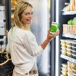 Mujer comprando kefir, uno de los alimentos fermentados más beneficiosos